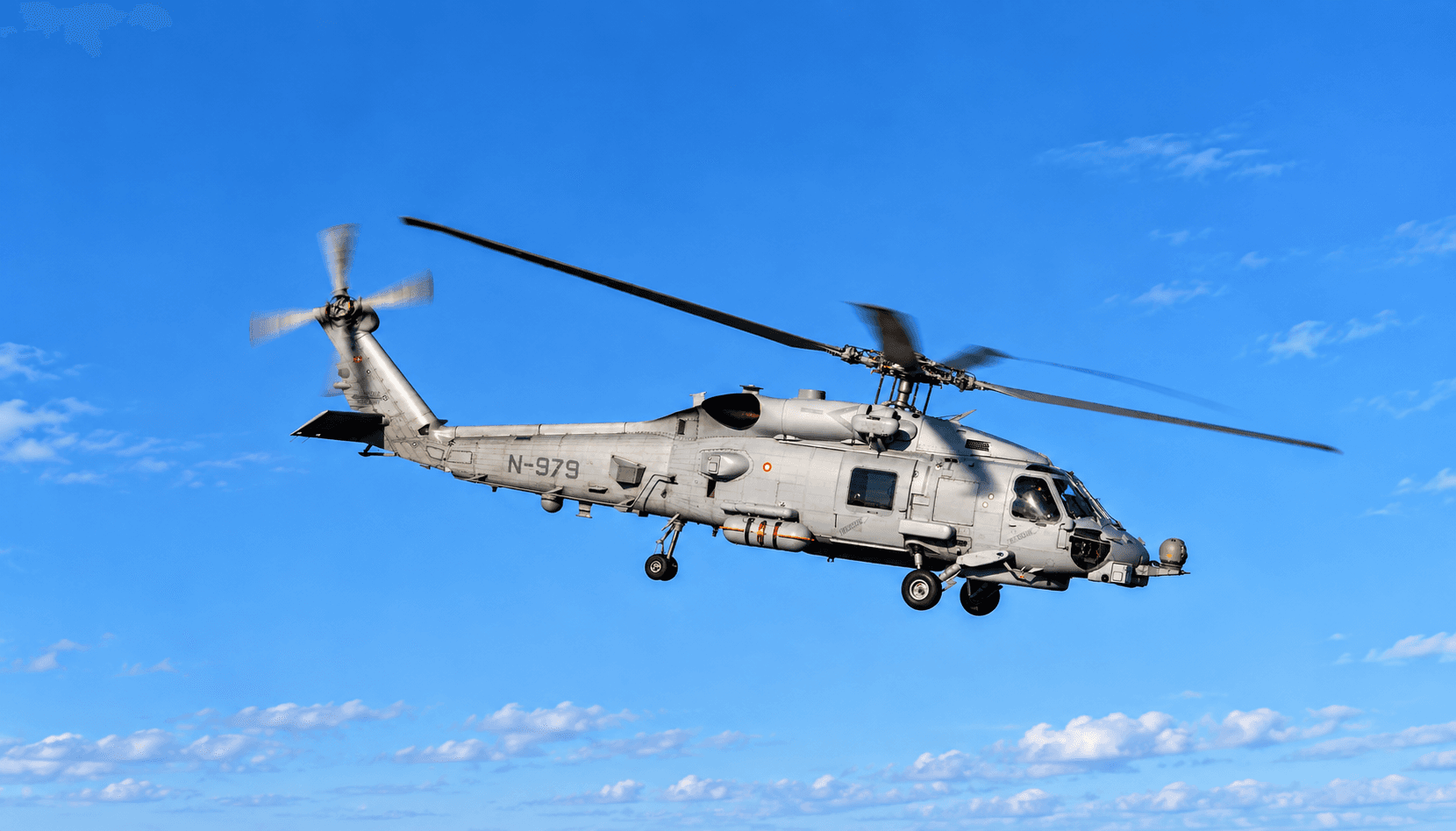 Naval utility helicopter in flight over open water