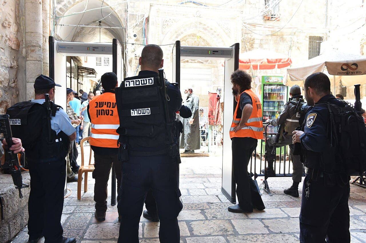 Walk-through metal detector archways in use at a monitored pedestrian entrance