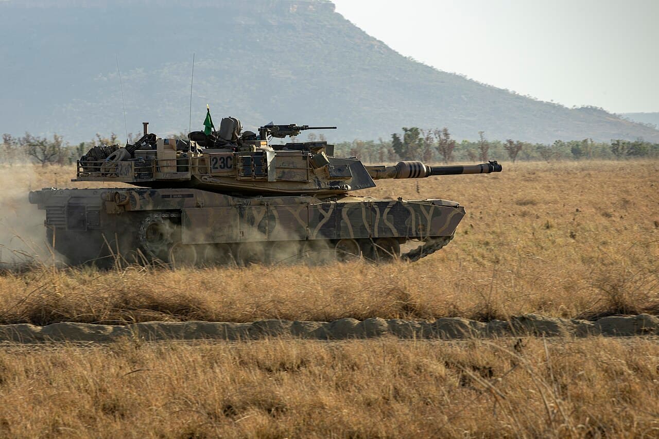 Main battle tank moving across open terrain during a live exercise